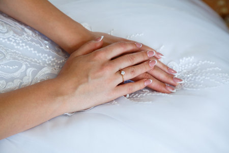 gold wedding rings in hands of newlyweds on wedding dayの写真素材