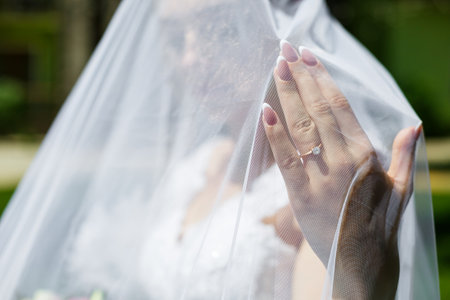 gold wedding rings in hands of newlyweds on wedding dayの写真素材