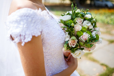 Beautiful wedding bouquet of flowers in the hands of the newlywedsの写真素材