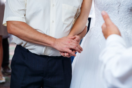 Bride and groom hold hands on wedding dayの写真素材