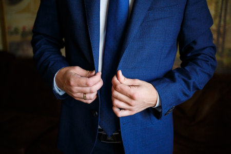 man puts on a suit on the wedding dayの写真素材