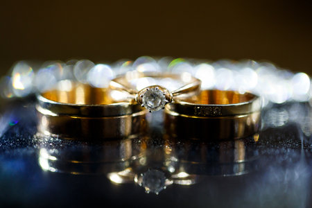 Gold wedding ring on black glassの写真素材