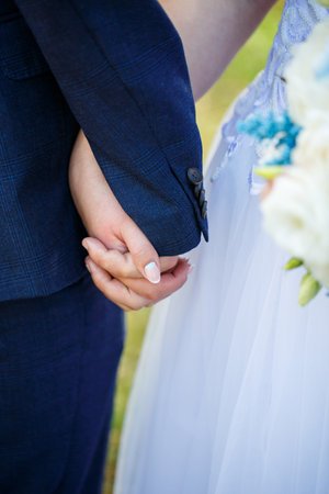 Bride and groom hold hands on wedding dayの写真素材