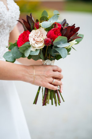 Beautiful wedding bouquet of flowers in the hands of the newlywedsの写真素材