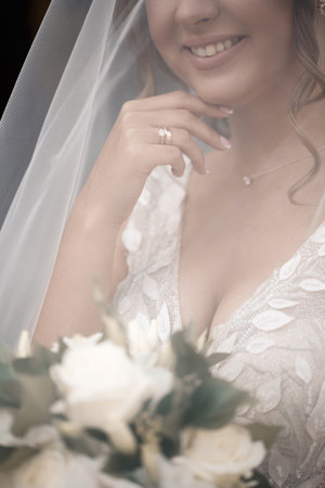 Gentle female hands of the bride with a gold wedding ring on the ring fingerの写真素材