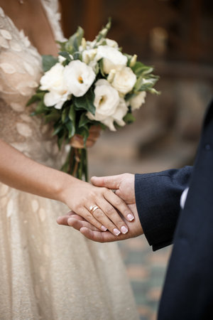 Newlyweds on wedding day, wedding couple holding hands, bride and groomの写真素材