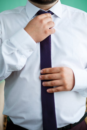 man puts on a suit on the wedding dayの写真素材