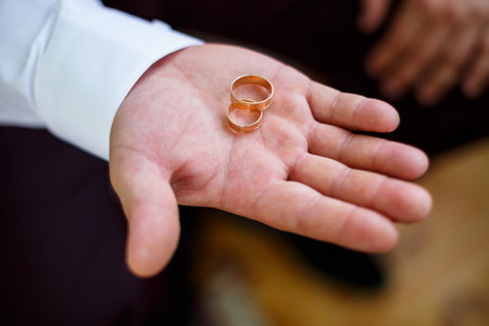 gold wedding rings in the hands of the newlywedsの写真素材