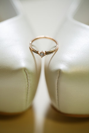 Gold wedding ring with women's shoes on the wedding day