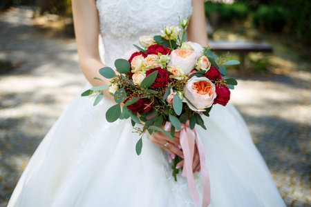 Beautiful wedding bouquet of flowers in the hands of the newlywedsの写真素材