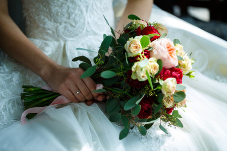 Beautiful wedding bouquet of flowers in the hands of the newlywedsの写真素材