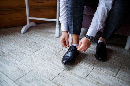 Male businessman puts on stylish shoes. Clothes for menの写真素材