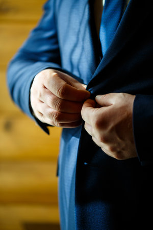 Man puts on a wedding suit and accessories on the wedding day.の写真素材
