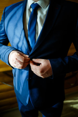Man puts on a wedding suit and accessories on the wedding day.の写真素材