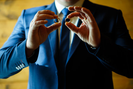 gold wedding rings in the hands of the newlywedsの写真素材