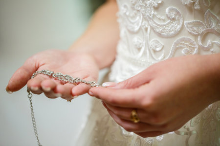 bride puts on wedding jewelry on the wedding dayの写真素材