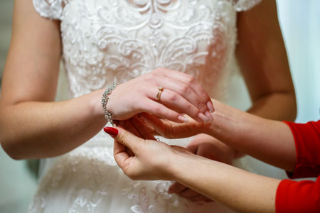 bride puts on wedding jewelry on the wedding dayの写真素材