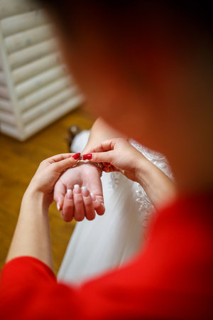 bride puts on wedding jewelry on the wedding dayの写真素材