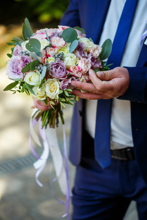 Wedding bouquet in the hands of the newlywedの写真素材