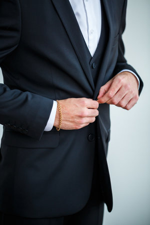 Stylish man businessman buttoning a button on a black jacketの写真素材