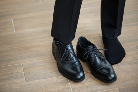 Male businessman puts on stylish shoes. Clothes for menの写真素材