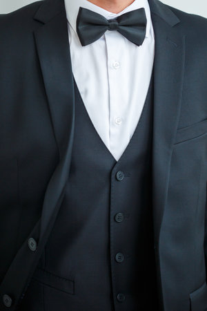 Young male businessman puts on a shirt and a stylish suit before a meetingの写真素材
