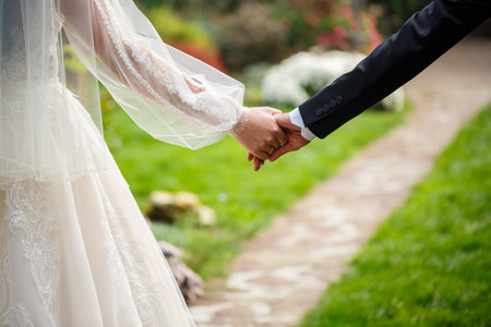 Newlyweds on wedding day, wedding couple holding hands, bride and groomの写真素材
