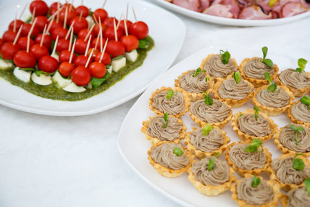 Nicely decorated banquet table with a variety of snacks and sandwich appetizersの写真素材