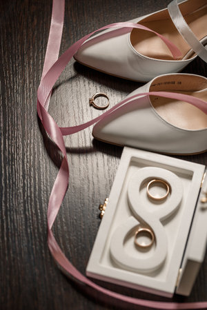 Wedding shoes for the bride. White high-heeled shoes near wedding rings, wedding jewelry. Marriage conceptの写真素材