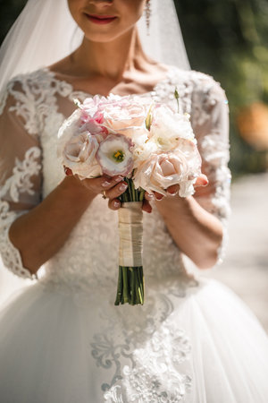 A bouquet of fresh flowers in the hands of the brideの写真素材