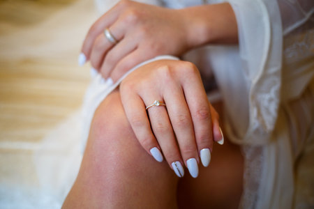 The bride's golden wedding ring on her finger on her wedding dayの写真素材