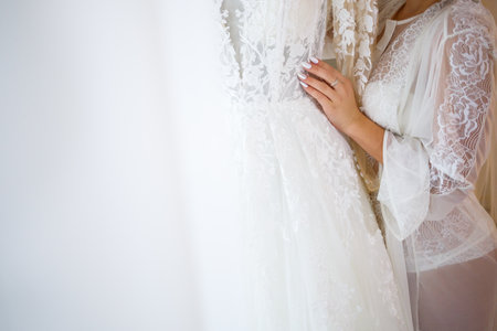 the bride holds in her hands a beautiful wedding dressの写真素材