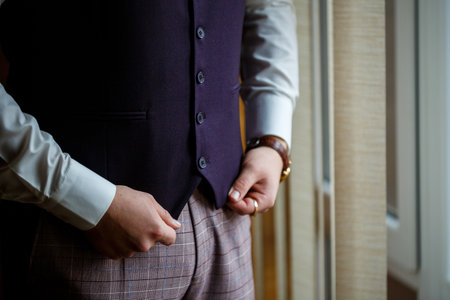 Man puts on a wedding suit and accessories on the wedding day.の写真素材