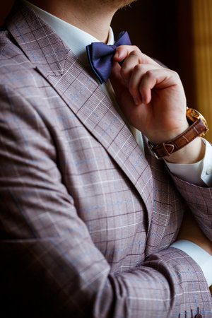 Man puts on a wedding suit and accessories on the wedding day.の写真素材