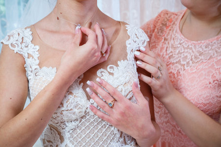 bride puts on wedding jewelry on the wedding dayの写真素材