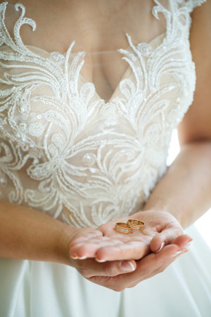 gold wedding rings in the hands of the newlywedsの写真素材