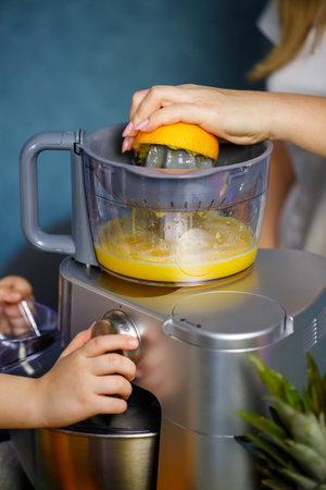Mom and daughter make an orange fresh. They are in white t-shirts.の写真素材
