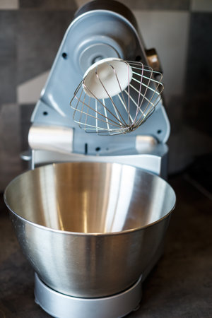 Beating eggs with sugar in a kitchen machine. Cream nozzleの写真素材