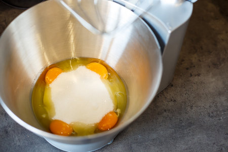 Beating eggs with sugar in a kitchen machine. Cream nozzleの写真素材