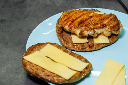 homemade hamburger with chicken, sauce and cheese fried on an electric grillの写真素材