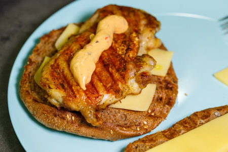 homemade hamburger with chicken, sauce and cheese fried on an electric grillの写真素材