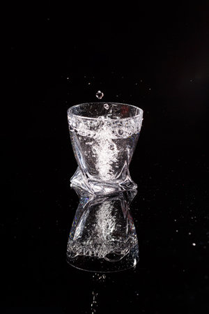 The black background is a scan in which water pours. Splashing water on glassの写真素材