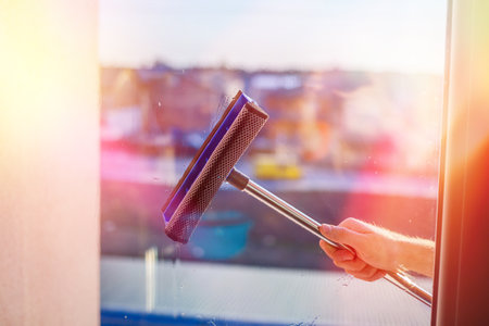 Window cleaning in high-rise buildings, houses with a brush. Window cleaning brush. Large window in a multi-storey building, cleaning service. Dust removal and glass washing.の写真素材