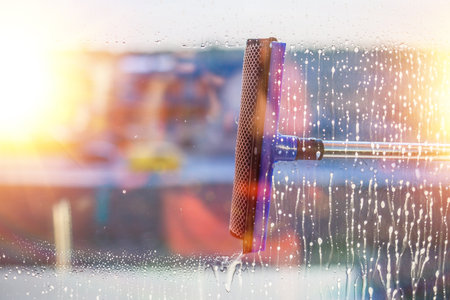 Window cleaning brush. Large window in a multi-storey building, cleaning service. Window cleaning in...