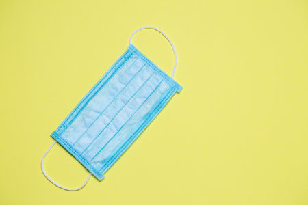 Blue medical surgical mask for protection against the virus on a colored background