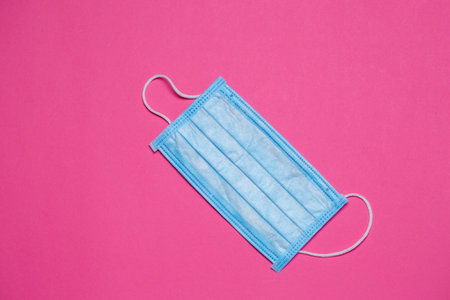 Blue medical surgical mask for protection against the virus on a colored background