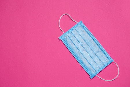 Blue medical surgical mask for protection against the virus on a colored background