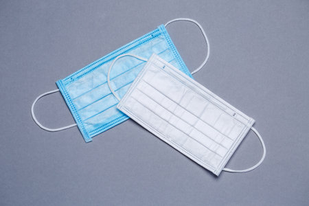 Blue and white medical surgical mask for protection against the virus on a colored background