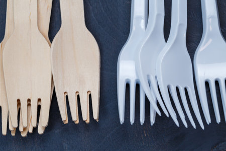 Zero waste concept. Wooden cutlery versus plastic cutlery. Eco-friendly disposable tableware made of...