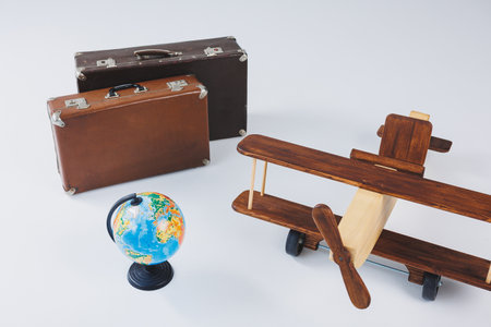 Wooden plane, world globe, brown suitcases. Travel around the worldの写真素材